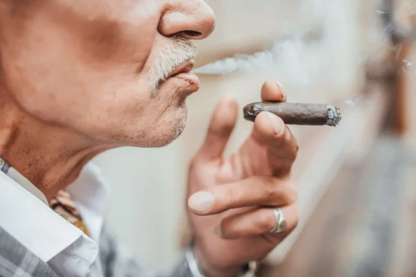 Homem com barba fumando seu charuto